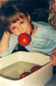 child holding apple in her mouth