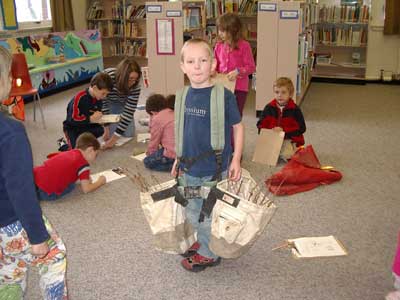 Figura 29. Un niño llevando bolsas de equipos para plantar árboles. 