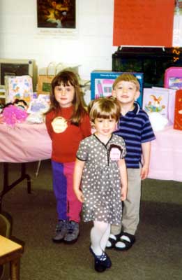 children posing in front of door prize table