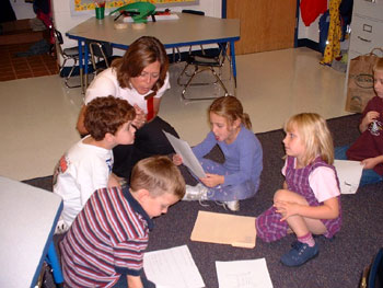 Children writing questions in a group.