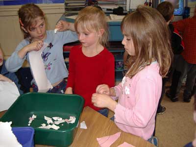 Figure 34. Children ripping paper to make recycled paper for their invitations.