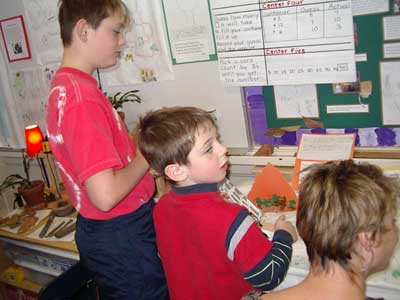 Figure 38. Child showing older brother and mother his model of trees.