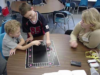 Figures 13 & 14. Children learn to play a board game.