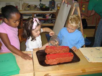 Figure 45. The children test a new clay levee to see if it will hold the water.
